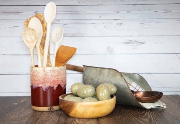 reddish brown handmade utensil holder with eggs in a bowl