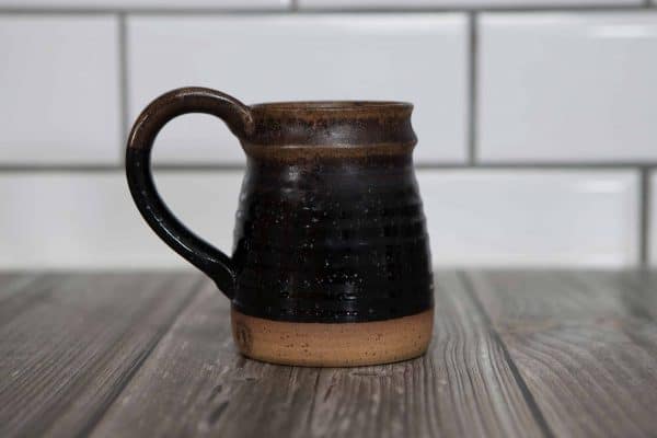 blackish brown mug with a handle