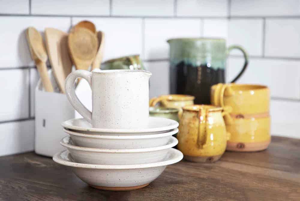 white, yellow, and green handmade pottery in a kitchen