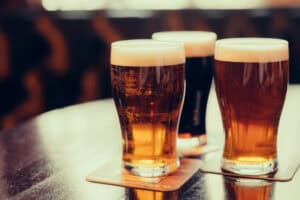 three types of beer sitting on a table at a brewery in sevierville